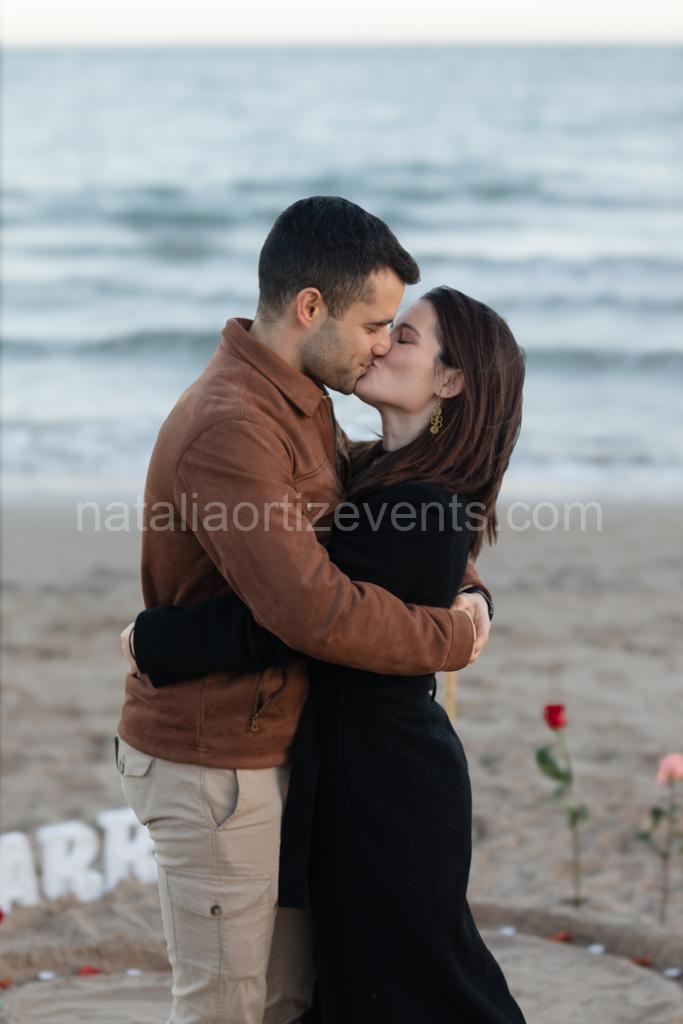 Pedida de mano en la playa de Alicante con rosas y letras marry me | Foto vía Natalia Ortiz Events